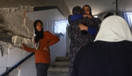 Palestinian women mourn and hug one another after an Israeli strike on a school housing displaced Palestinians in Jabalia in the northern Gaza Strip on April 17, 2025. (Photo by BASHAR TALEB / AFP)
