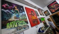 A man walks past horror movie posters titled 'Queen of the Southern Sea' and 'The Bloody Ring' at the Usmar Ismail Film Center in Jakarta on April 11, 2025. (Photo by Bay Ismoyo / AFP) 
