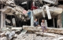 A boy and girl sit by the ruins of a destroyed building in Gaza City on April 21, 2025. (Photo by Omar Al Qattaa / AFP)