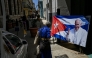 A man walks near a picture of the late Pope Francis on a street in Havana on April 22, 2025. (Photo by Yamil Lage / AFP)
