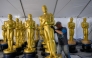 A worker lines up Oscar statues, as preparations are underway for the 95th Oscars Academy Awards, in Hollywood, California, on March 9, 2023. (Photo by ANGELA WEISS / AFP)

