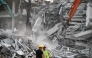 Heavy construction equipment is used by rescue teams trying to find people trapped in the rubble at the site of an under-construction building collapse in Bangkok on March 29, 2025. (Photo by Manan Vatsyayana / AFP)

