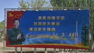 A poster of China's President Xi Jinping is seen beside a slogan referencing China's space ambitions at the Jiuquan Satellite Launch Centre in the Gobi desert in northwest China on April 23, 2025, a day before the launch of the Shenzhou-20 mission. (Photo by Pedro Pardo / AFP)
