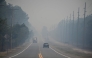 Smoke from the Jones Road Fire covers a road near Lacey Township in Ocean County, New Jersey, on April 23, 2025. (Photo by Matthew Hatcher / AFP)