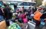 Sub-Saharan migrants queue to board a bus with their belongings as they head to a repatriation flight, leaving Tunis for their countries of origin on March 4, 2023. (Photo by Fethi Belaid / AFP)