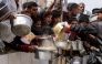 People queue with pots to receive charity meals from a kitchen in Beit Lahia in the northern Gaza Strip on April 24, 2025. Israel on March 18 resumed its intense military offensive in the Palestinian territory after a ceasefire deal that came into effect on January 19 fell apart two months later over differences regarding its next phase. (Photo by Bashar TALEB / AFP)