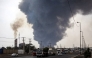 A thick plume of smoke billows as motorists drive their vehicles along a highway near the source of an explosion at the Shahid Rajaee port dock southwest of Bandar Abbas in the Iranian province of Hormozgan on April 26, 2025. Photo by Mohammad Rasole MORADI / IRNA / AFP.