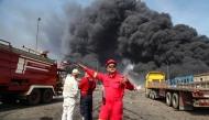 Thick, black smoke rises as rescuers arrive near the source of an explosion at the Shahid Rajaee port dock southwest of Bandar Abbas in the Iranian province of Hormozgan on April 26, 2025. (Photo by MOHAMMAD RASOLE MORADI / IRNA / AFP)
