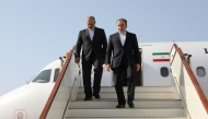 This handout picture provided by the Iranian Foreign Ministry shows Iran's Foreign Minister Abbas Araghchi (R) descending the stairs of his plane upon his arrival in Muscat on April 25, 2025. (Photo by Iranian Foreign Ministry / AFP)