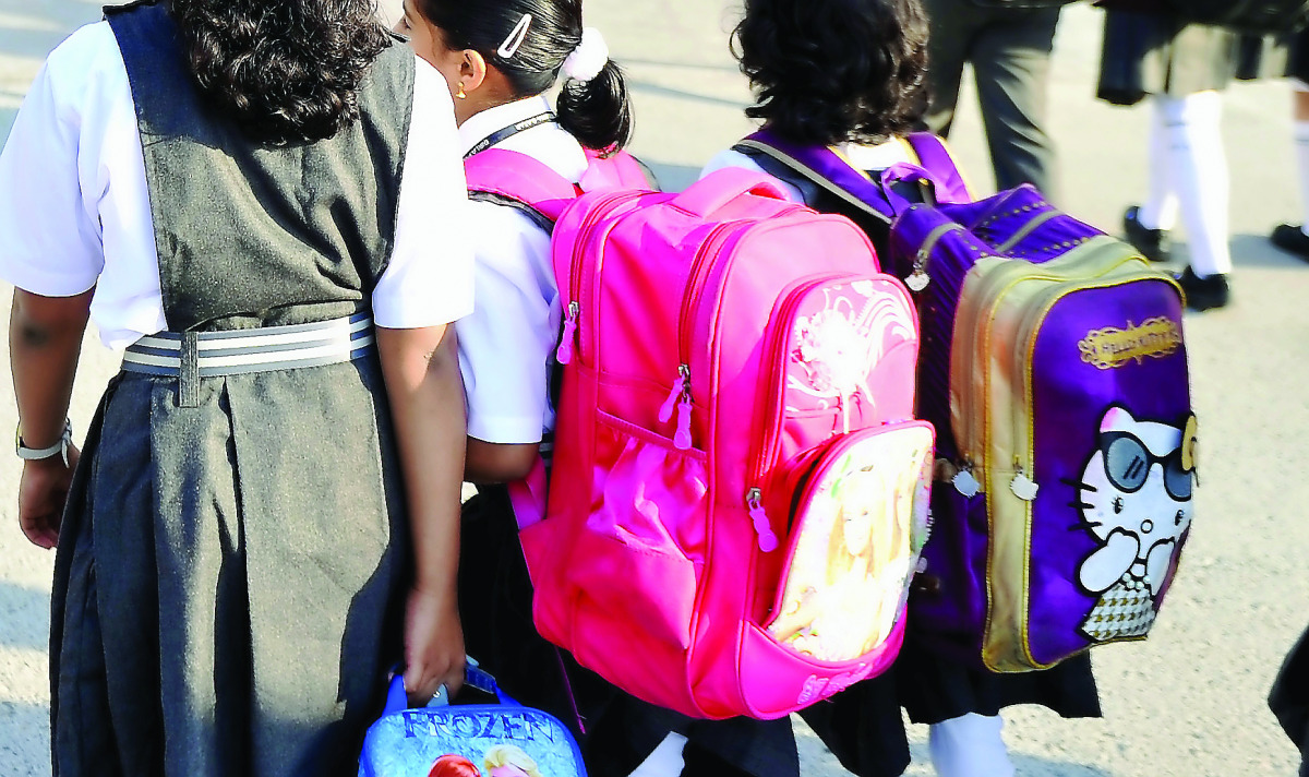 Young children with their heavy school bags in a private school. Pic: Abdul Basit / The Peninsula
