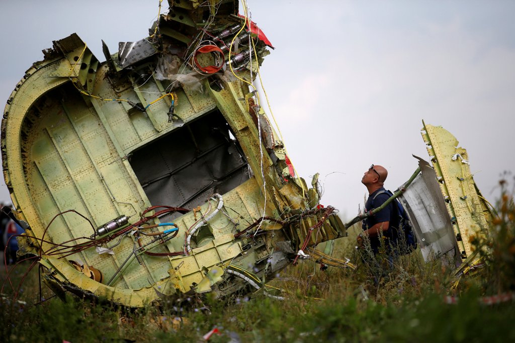 A Malaysian air crash investigator inspects the crash site of Malaysia Airlines Flight MH17, near the village of Hrabove (Grabovo) in Donetsk region, Ukraine, July 22, 2014. REUTERS/Maxim Zmeyev