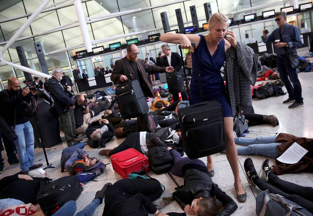 Climate activist group Reclaim the Power lie on the ground and carry luggage during a protest against airport expansion plans at Heathrow Airport in London, Britain October 1, 2016. REUTERS/Neil Hall
