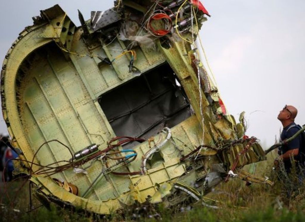 A Malaysian air crash investigator inspects the crash site of Malaysia Airlines Flight MH17, near the village of Hrabove (Grabovo) in Donetsk region, Ukraine, July 22, 2014. REUTERS/Maxim Zmeyev