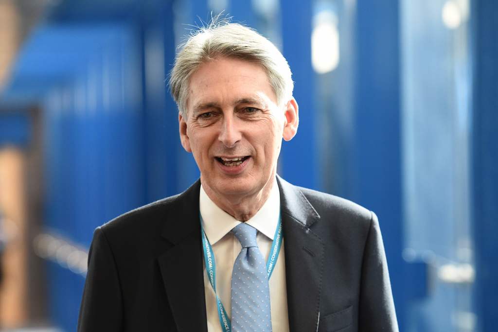 British Chancellor of the Exchequer Philip Hammond walks along the bridge from the hotel to the International Convention Centre in Birmingham, central England, on October 2, 2016 on the first day of the Conservative party annual conference. Britain's gove