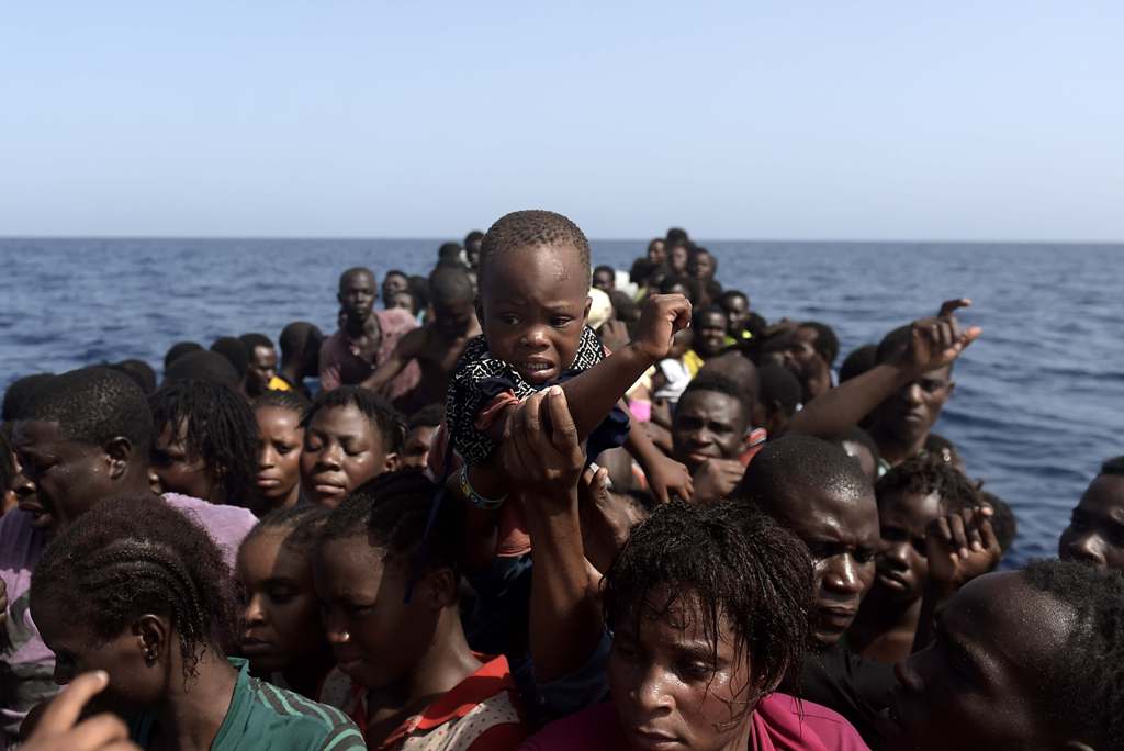 Migrants wait to be rescued by members of Proactiva Open Arms NGO in the Mediterranean Sea, some 12 nautical miles north of Libya, on October 4, 2016.AFP / ARIS MESSINIS
