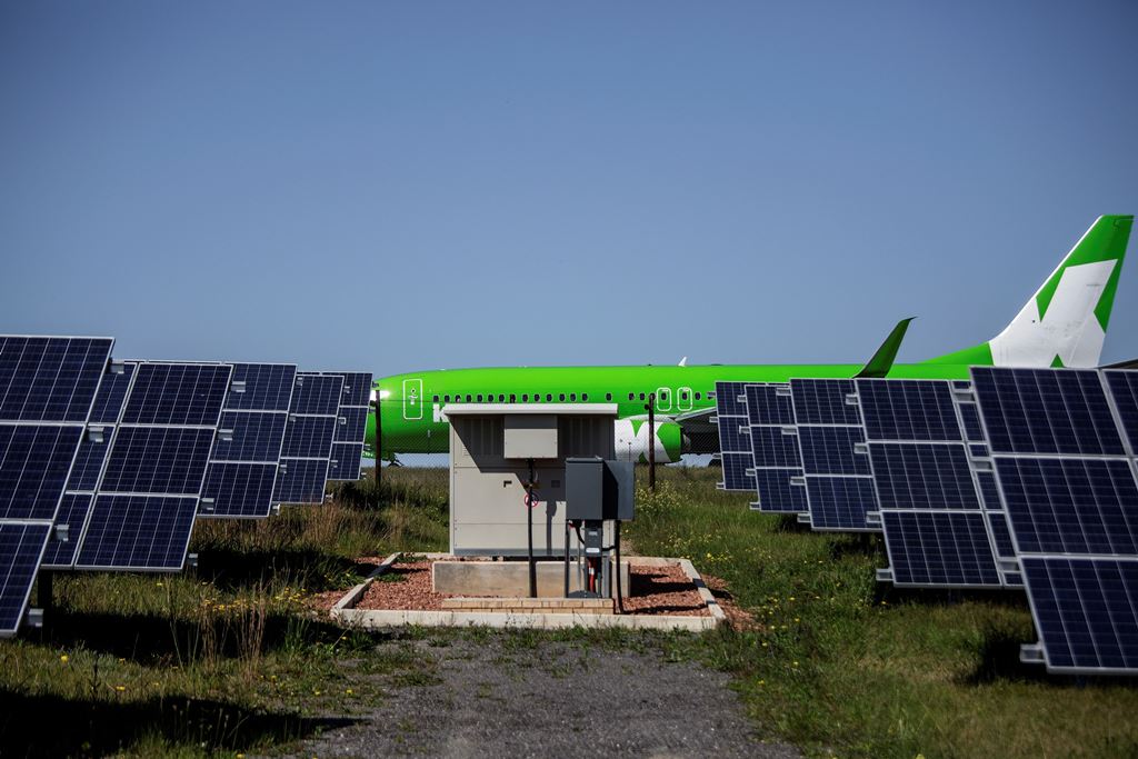 A passenger commercial aircraft on the runway at George Airport before take off, as solar panels are seen in the foreground. AFP / GIANLUIGI GUERCIA 
