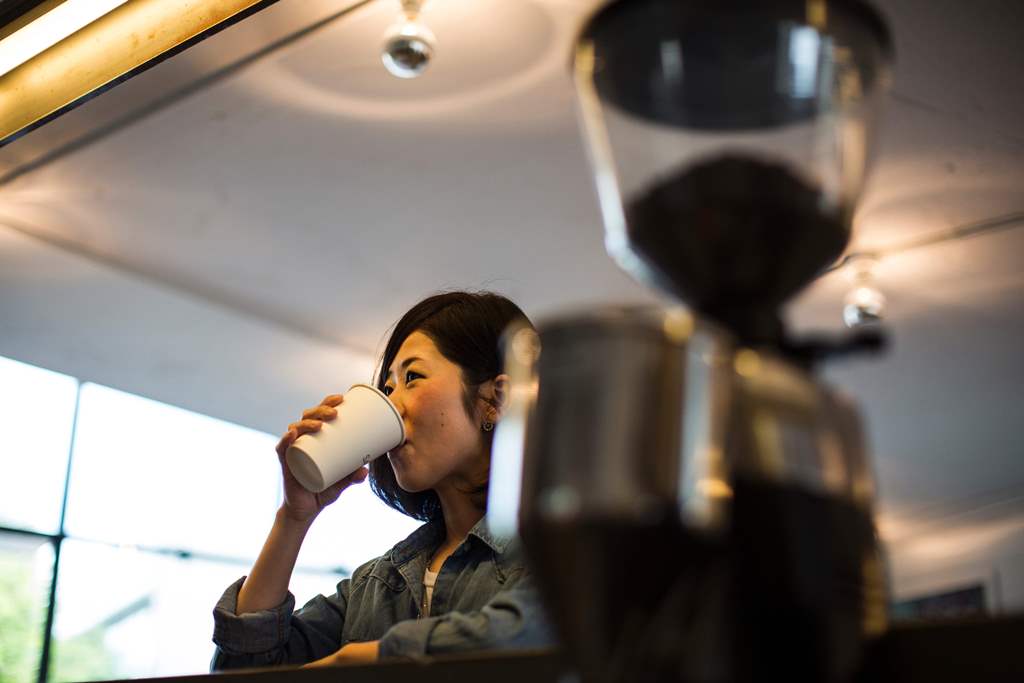 A Japanese woman drinks her beverage at a coffee shop in Tokyo. AFP / BEHROUZ MEHRI