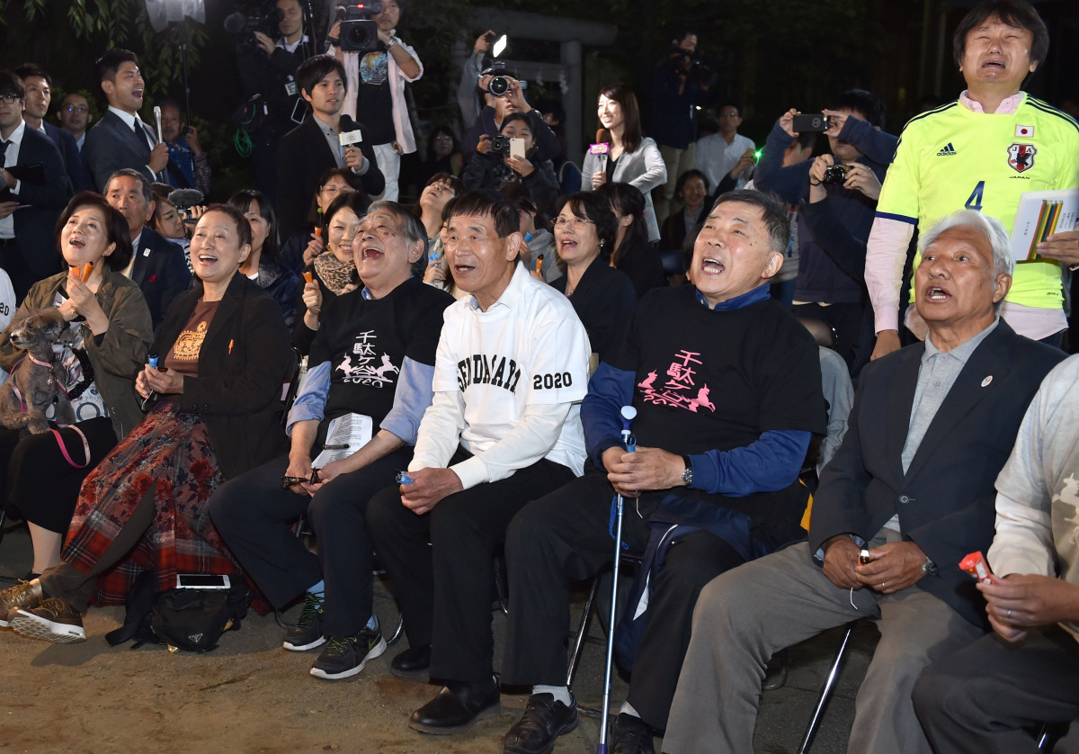  Fans of Japanese novelist Haruki Murakami react when the Swedish Academy awarded the Nobel prize for literature to US musician Bob Dylan at a shrine in Tokyo on October 13. 2016. US music legend Bob Dylan won the Nobel Literature Prize on October 13, the