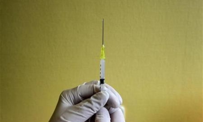 A nurse prepares a H1N1 flu vaccine shot at a hospital in Budapest, Hungary, November 20, 2009. (REUTERS / Karoly Arvai)