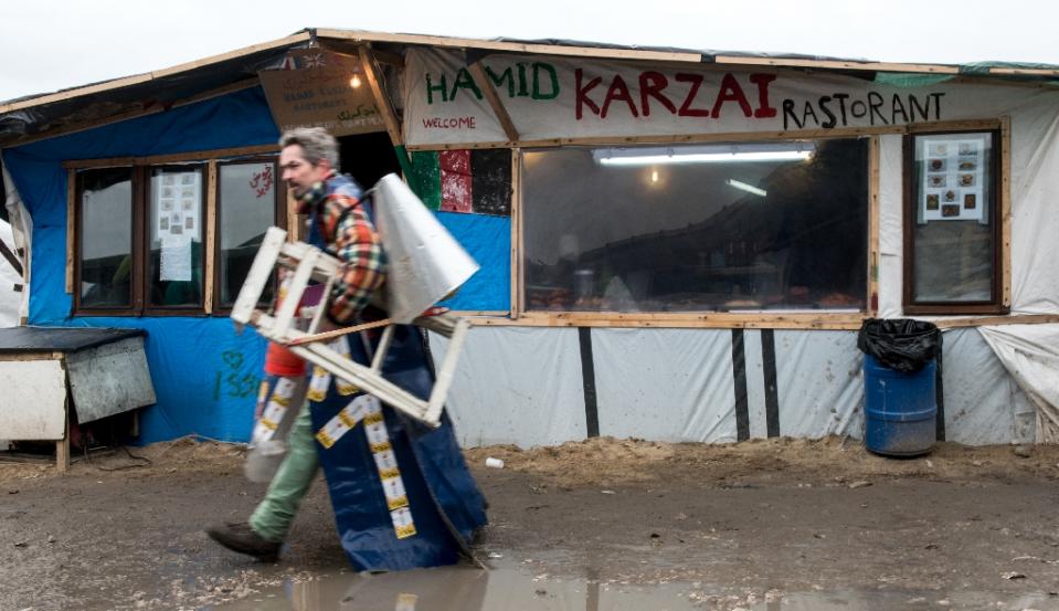 A migrant walks past a makeshift restaurant in the so-called Jungle migrant camp in Calais on February 23, 2016 (AFP /Denis Charlet)