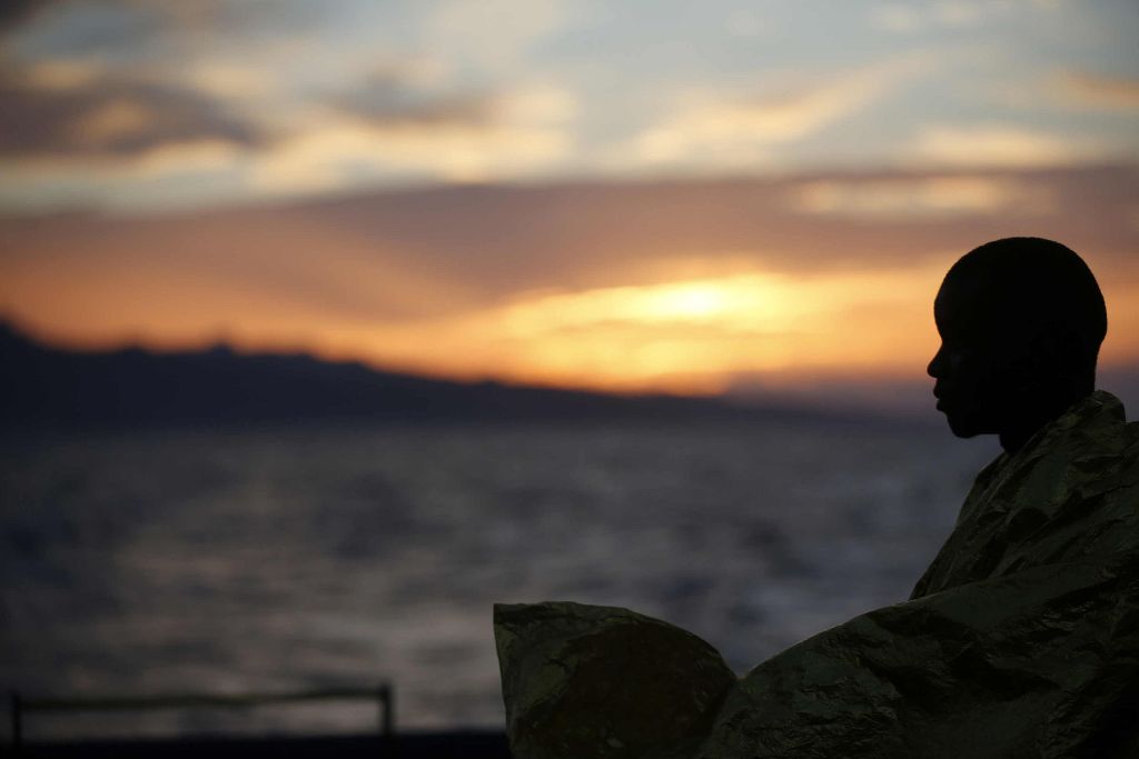 This handout picture taken and released by the Italian Red Cross on October 22, 2016 shows a migrant wrapped in a survival foil blanket after landing in Vibo Marina, southern Italy, following a rescue operation in the Mediterranean Sea. / AFP photo.