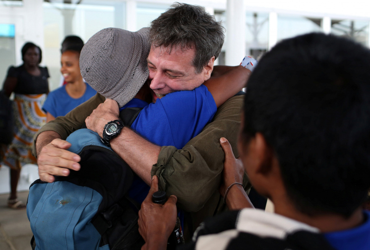 Some of the 26 Asian sailors released after being held captives by Somalia pirates for more than four years become emotional as they greet Michael Scott Moore (C), a former hostage who said that he was involved in helping with their release, as they arriv