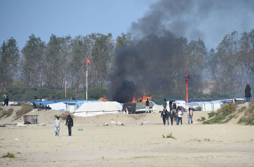 Migrants gather together during the full evacuation of the Calais 