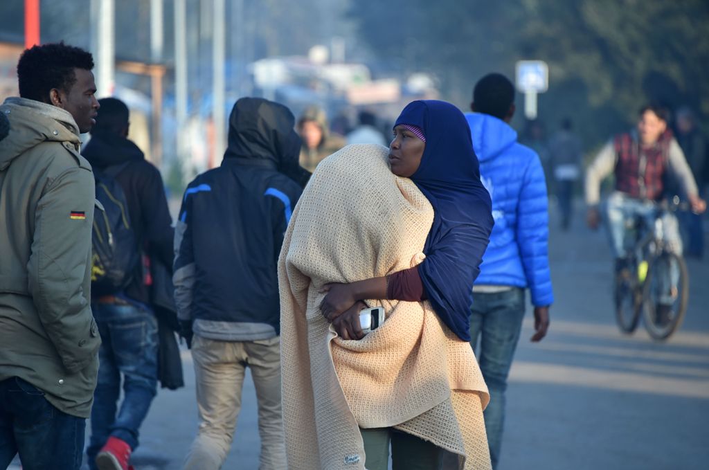 Migrants talk during the full evacuation of the 