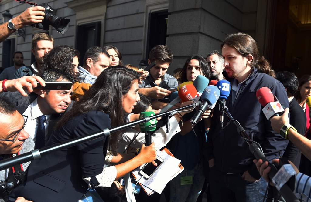 Leader of anti-austerity party Podemos, Pablo Iglesias (R) listens to journalists during a break on the second day of the parliamentary investiture debate to vote through a prime minister, on October 27, 2016, in Madrid. AFP / GERARD JULIEN
