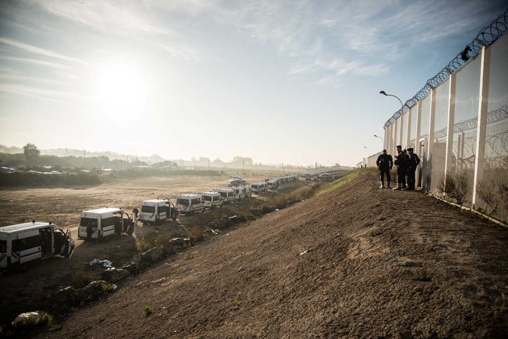 Police officers wait at the Calais 'jungle' camp during the fourth day of evacuation in Calais, France on October 27, 2016.   NnoMan - Anadolu Agency 