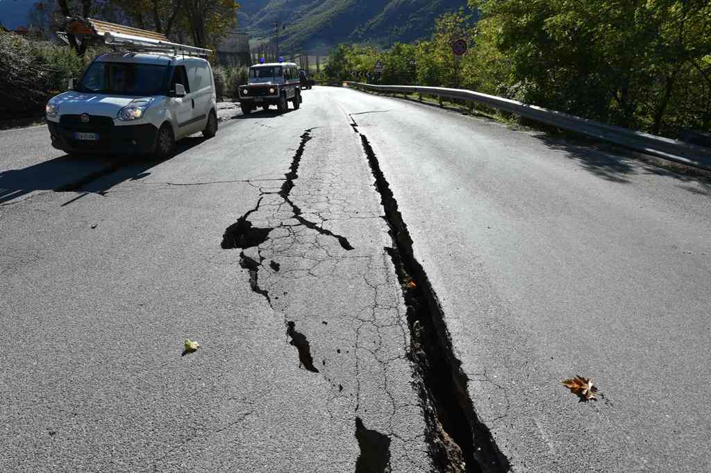 A picture shows cracks on the road outside the center of Norcia after a 6.6 magnitude earthquake on October 30, 2016.  AFP / ALBERTO PIZZOLI
