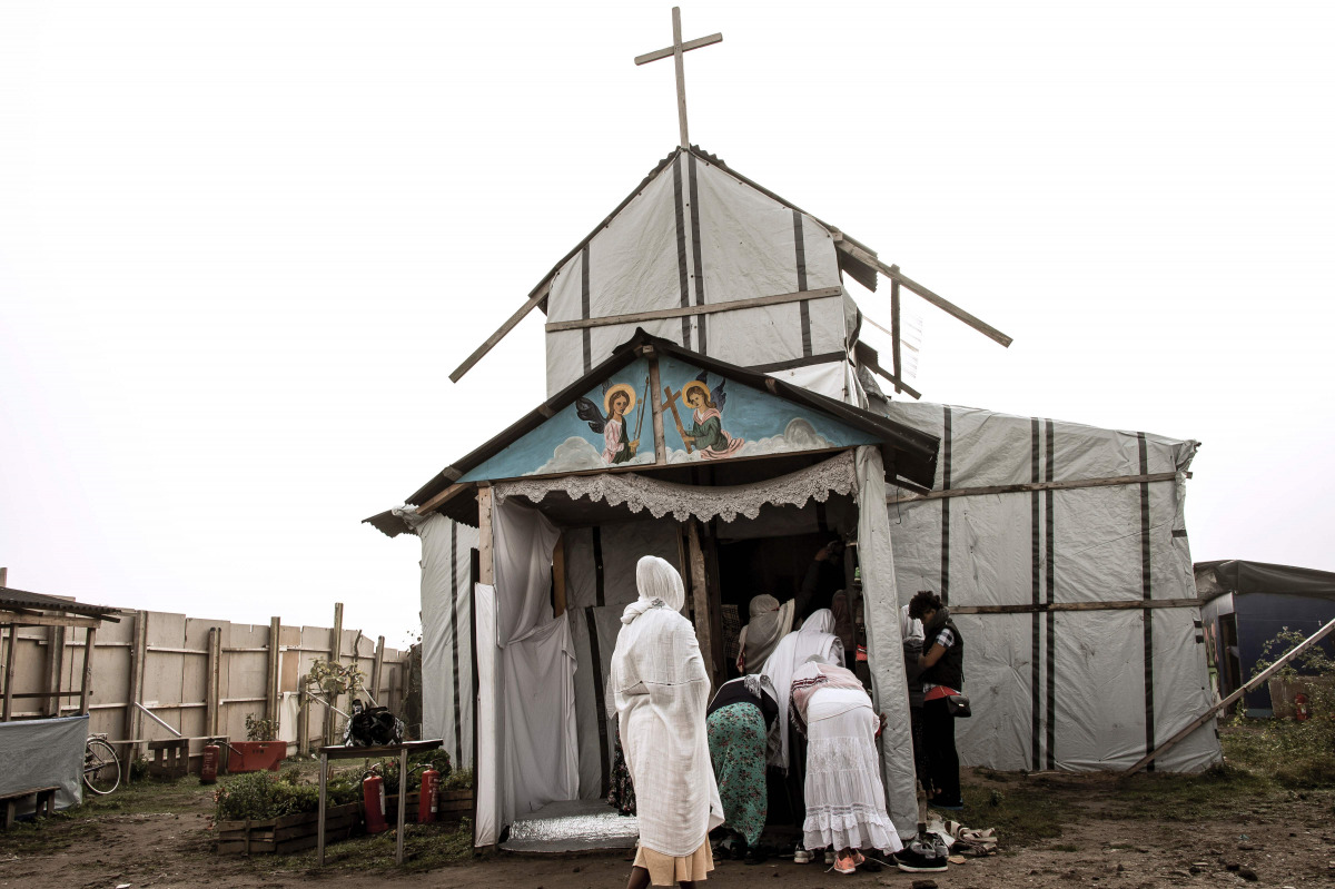 Ethiopian Coptic migrants arrive for a mass at the makeshift Orthodox church in the Jungle