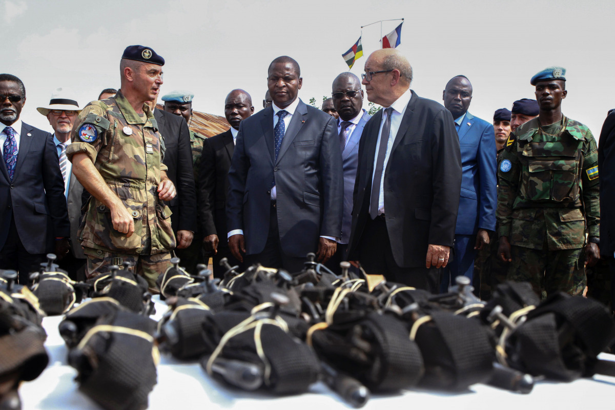 French Defence Minister Jean-Yves Le Drian (C) flanked by President of the Central African Republic Faustin-Archange Touadera (2ndL), looks at military supplies at the Mpoko military base in Bangui on October 31, 2016. France on October 31, 2016 formally 