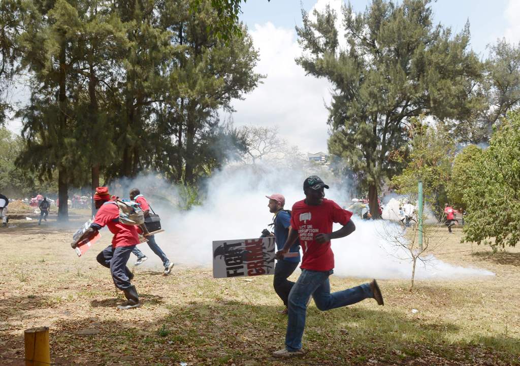 Kenyan human rights activists run from anti-riot police in Nairobi on November 3, 2016, during a demonstration calling for President Uhuru Kenyatta to have more effective actions against political corruption. / AFP / SIMON MAINA