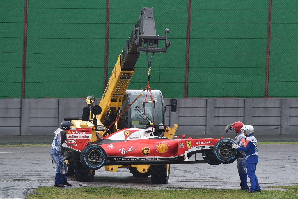 The car of Scuderia Ferrari's Finnish driver Kimi Raikkonen is removed from the track after he crashed and the race was stopped during the Brazilian Grand Prix at the Interlagos circuit in Sao Paulo, Brazil, on November 13, 2016. / AFP / Miguel SCHINCARIO