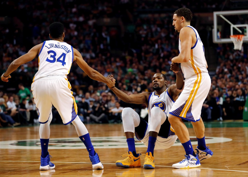 Golden State Warriors guard Shaun Livingston (34) and Golden State Warriors guard Klay Thompson (11) help up Golden State Warriors forward Kevin Durant (35) during the first half against the Boston Celtics at TD Garden./Winslow Townson
