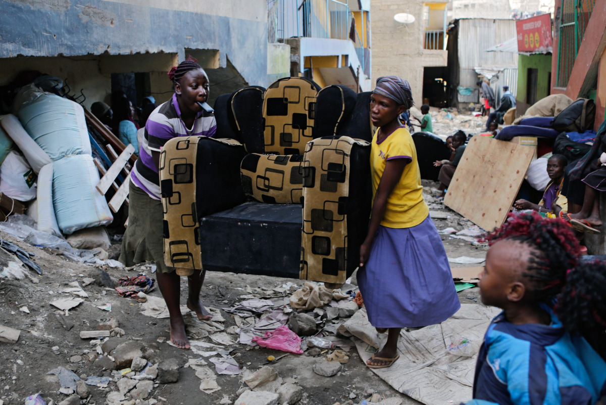 Women carry their belongings from a building next to a building that collapsed in the Huruma estate of the Mathare slum Nairobi Kenya May 3 2016 EPA