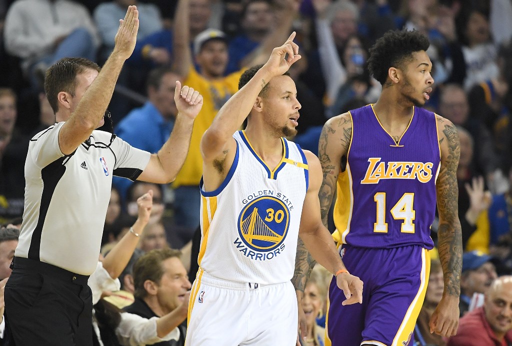 Stephen Curry #30 of the Golden State Warriors celebrates after making a three-point shot over Brandon Ingram #14 of the Los Angeles Lakers in the first half of their NBA basketball game at ORACLE Arena on November 23, 2016 in Oakland, California. Thearon