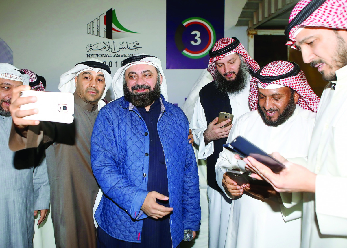 Kuwaiti Islamist candidate and opposition leader Waleed Al Tabtabaee (centre) celebrates with his supporters following the announcment of his victory in the parliamentary election, in Kuwait city, yesterday.