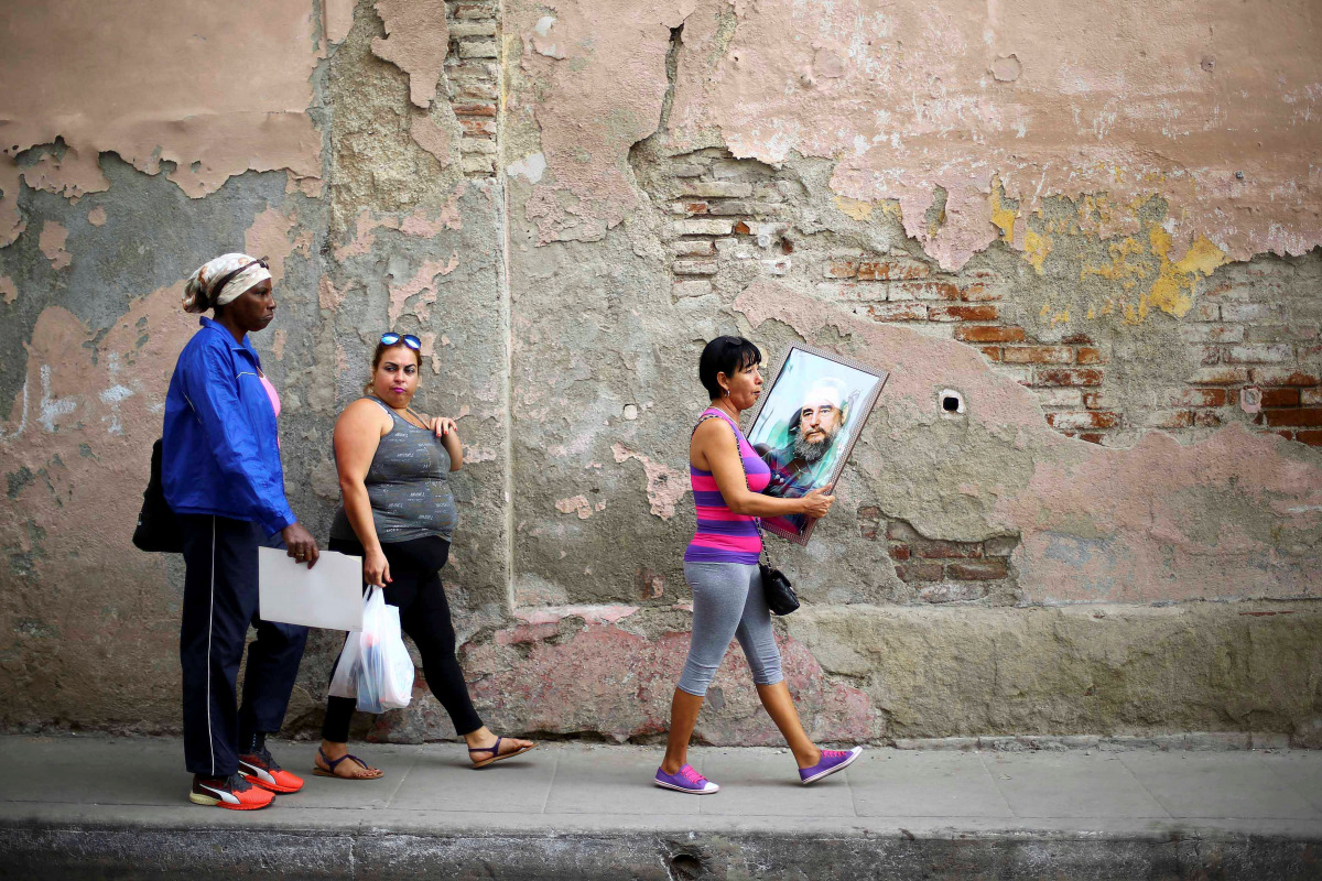 A woman carries a portrait of Cuba's late President Fidel Castro in Santa Clara, Cuba, November 30, 2016. REUTERS/Ivan Alvarado