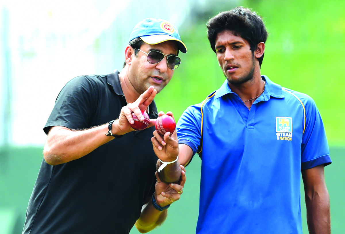 Pakistani cricket legend Wasim Akram offers tips to Sri Lankan bowler Kasun Rajitha during his first coaching session at the Sinhalese Sports Club (SSC) grounds in Colombo yesterday. Akram began his coaching tenure with the Sri Lankan cricket team yesterd