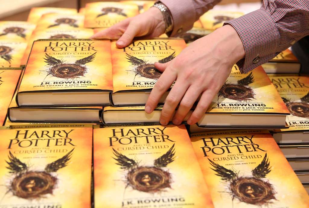 A store assistant holds copies of the book of the play of Harry Potter and the Cursed Child parts One and Two at a bookstore in London, Britain on July 31, 2016. REUTERS/Neil Hall/File Photo
