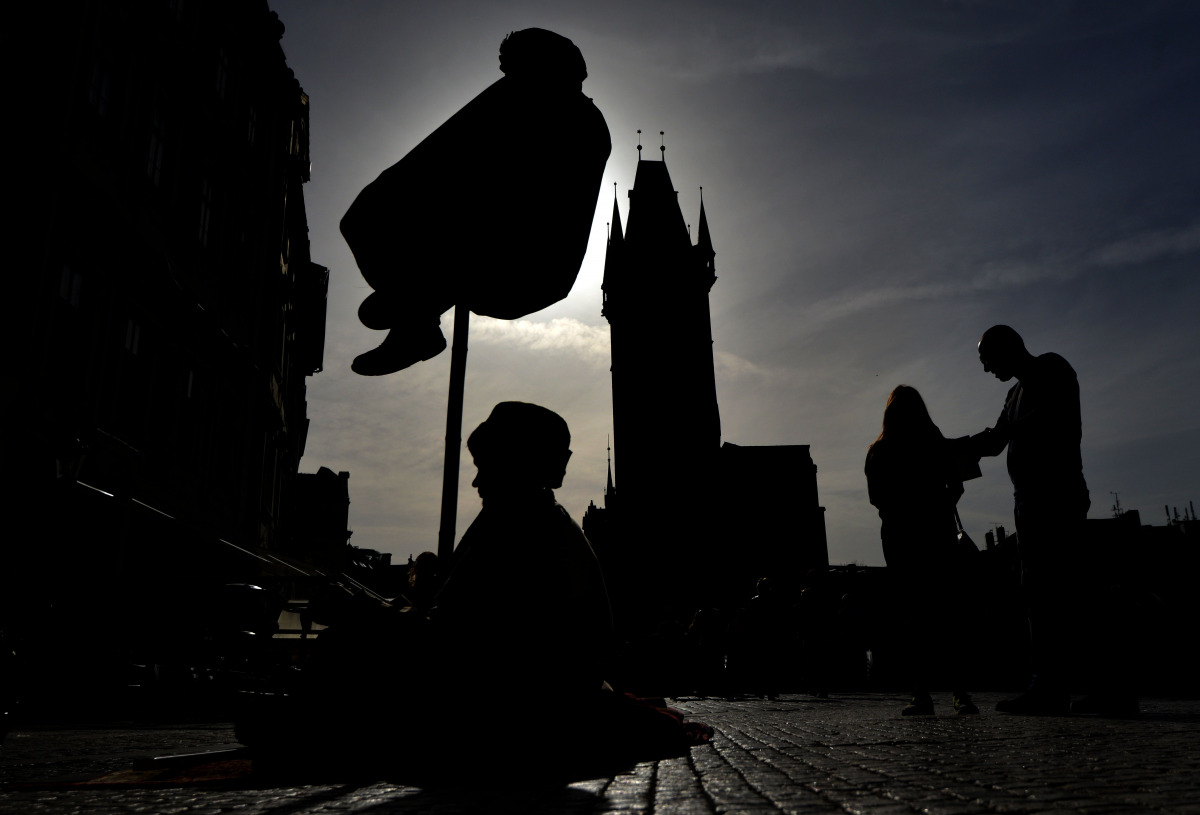 A couple look on the Street performers during a sunny day on April 5, 2016 on the Old Town Square in Prague (AFP / Michal Cizek) 