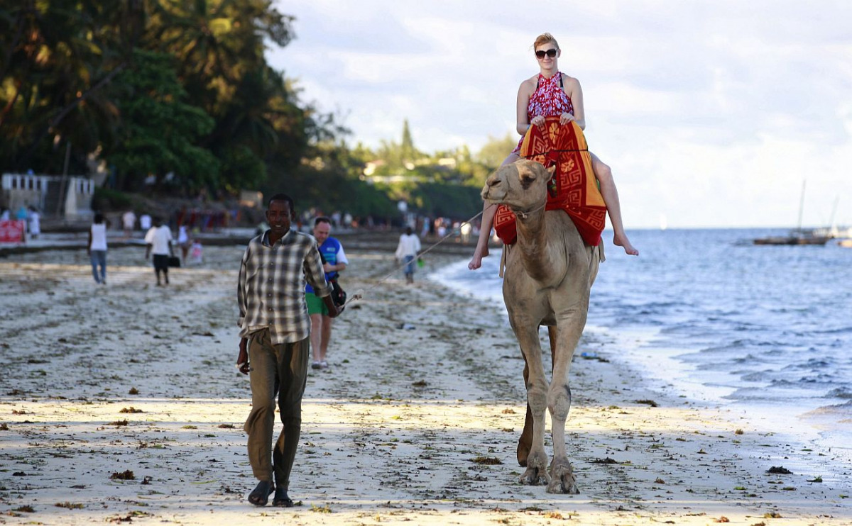 A tourist rides on a camel's back at the Jomo Kenyatta public beach in Kenya's coastal city of Mombasa, March 24, 2013. REUTERS/Joseph Okanga