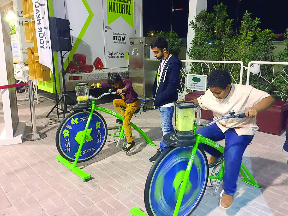 Children making smoothies with bike blenders.