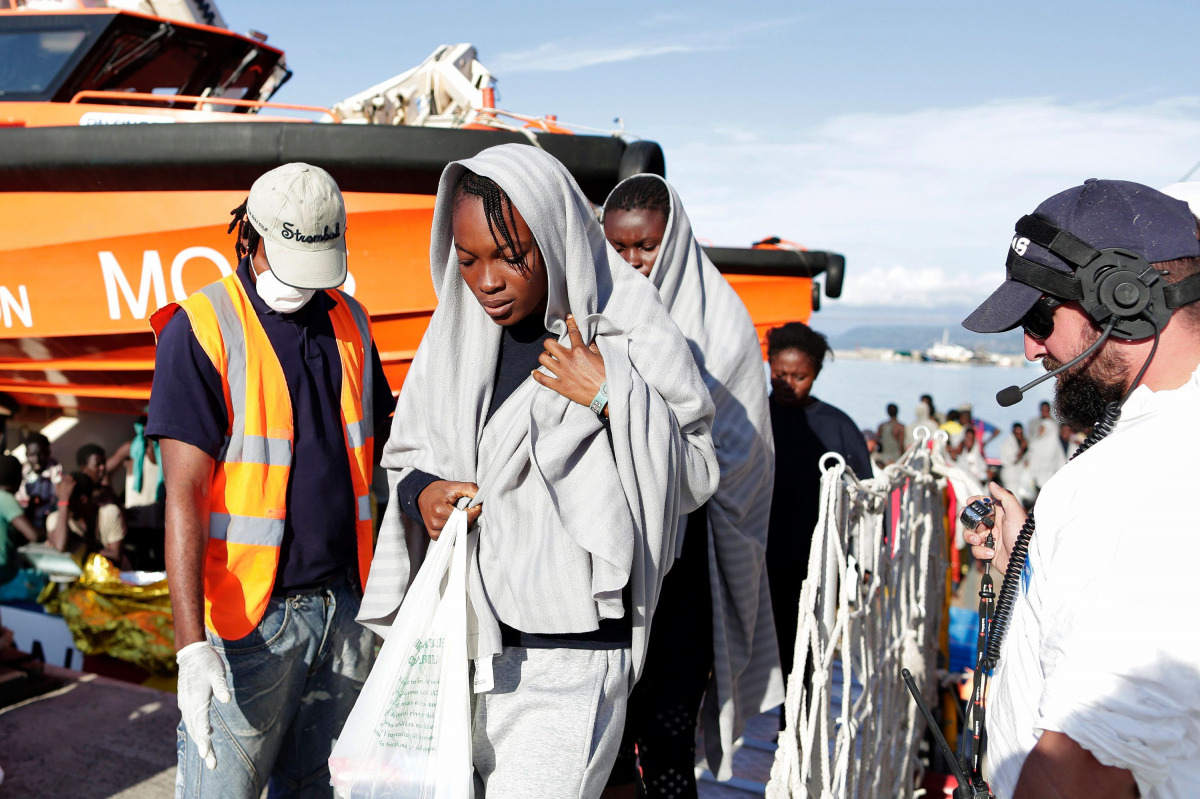 This handout picture taken and released by the Italian Red Cross on October 22 2016 shows migrants landing in Vibo Marina, after a rescue operation in the Mediterranean Sea (AFP) 