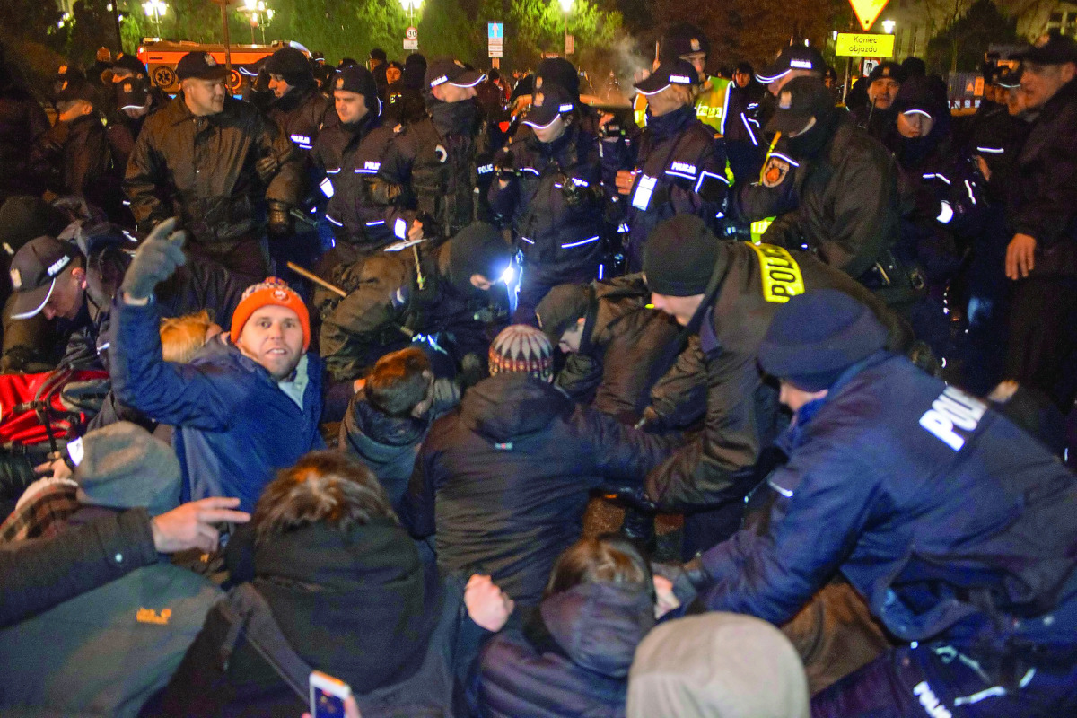 People scuffle with police as they try to block the road to the Polish Parliament in Warsaw.