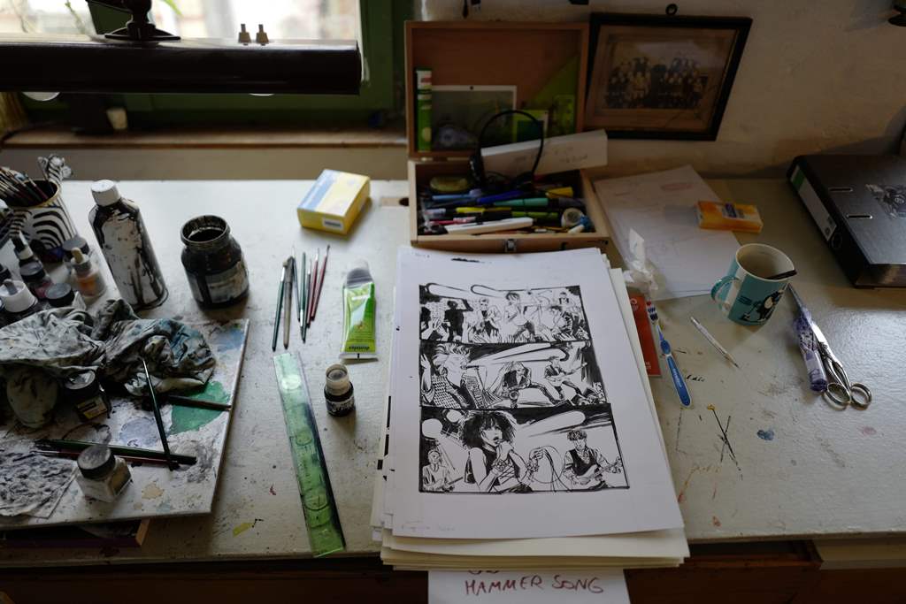 View of German cartoonist and comics author Reinhard Kleist's desk in his studio in Berlin on November 23, 2016. AFP / John MACDOUGALL 
