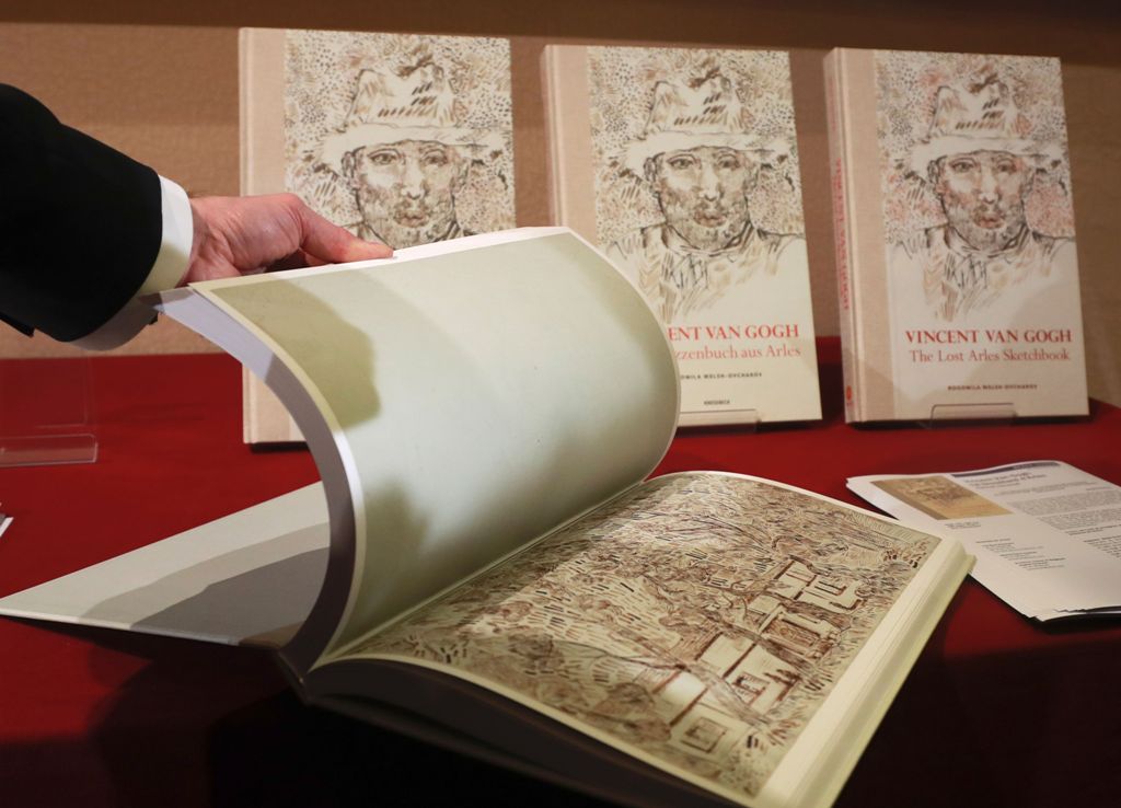 (FILES) This file photo taken on November 15, 2016 shows a man leafing through the pages of a book of drawings from Dutch post-impressionist painter Vincent Van Gogh at the architecture academy in Paris. / AFP / JACQUES DEMARTHON
