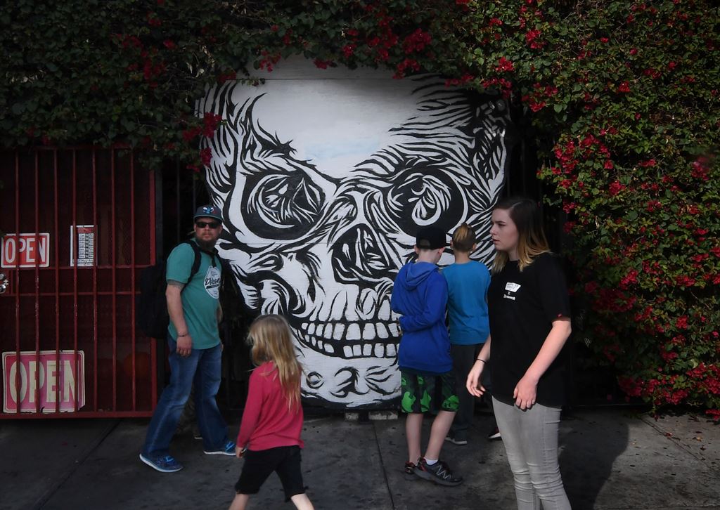 (FILES) This file photo taken on December 14, 2016 shows people walking by a mural at the Museum of Death in Hollywood, California. AFP / Mark Ralston 